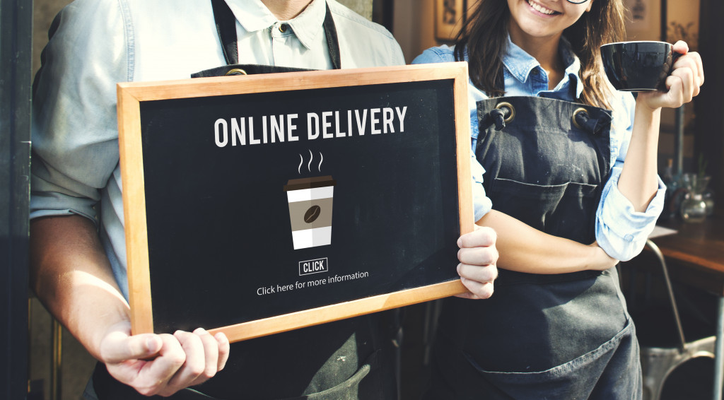 café staff holding a signage saying online delivery