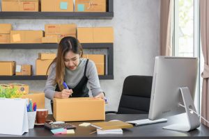 A woman labeling boxes for her online store