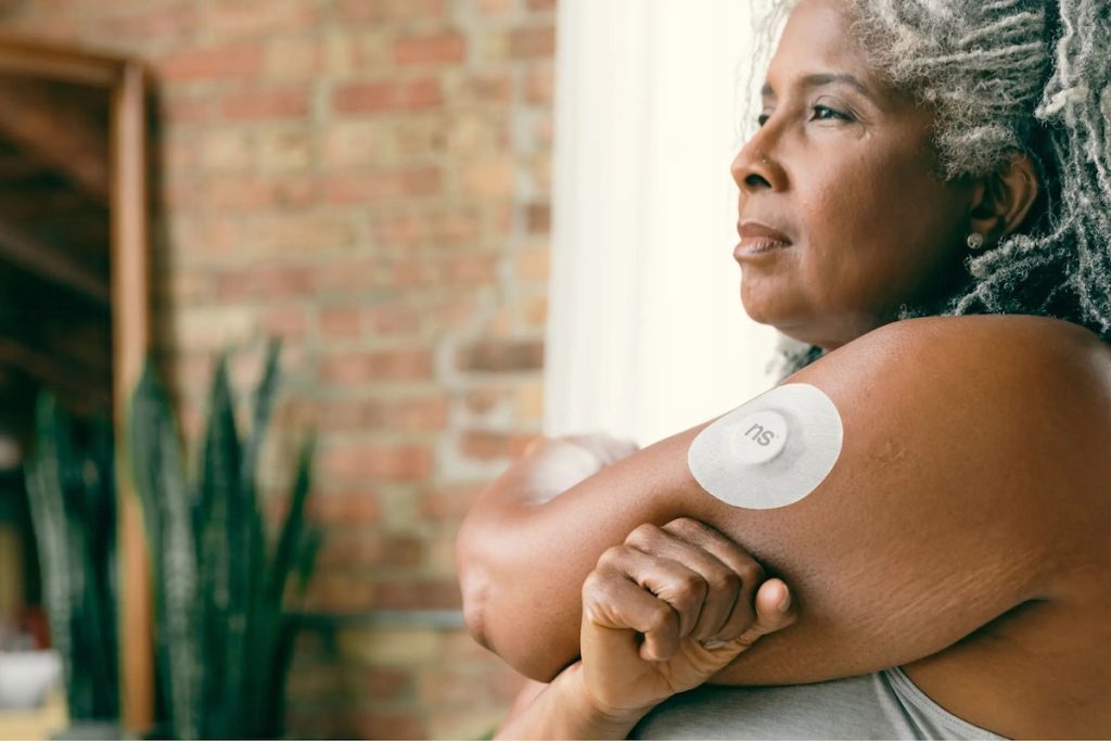 woman with diabetes wearing a CGM device on her arm