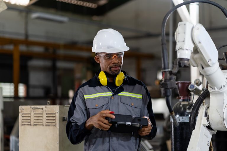 engineer holding robot controller for maintenance